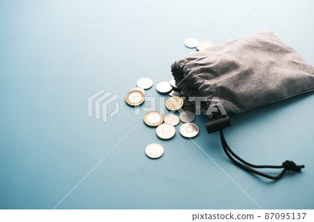 top view of coins spilling from a small bag top view of coins spilling from a small bag 87095137