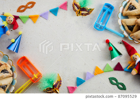 Jewish holiday Purim background with hamantaschen or hamans ears cookies, carnival mask and noisemaker 87095529
