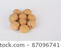 Walnuts on a white background are laid out in the shape of a flower 87096741