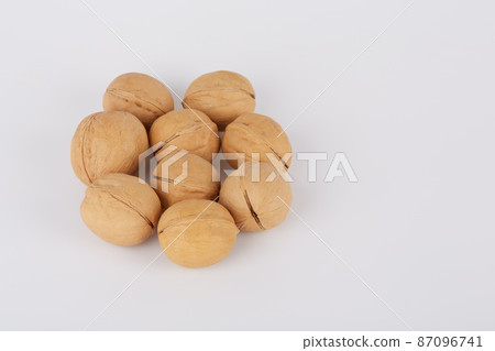 Walnuts on a white background are laid out in the shape of a flower 87096741