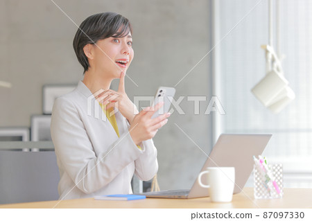一個拿著智能手機,把手放在下巴上幻想 1 的女商人 一個拿著智能手機,把手放在下巴上幻想 1 的女商人 87097330