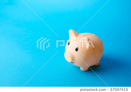 Piggy bank on a blue background. Economy. Pension fund. Deposit banking. Earn more money and save assets from inflation risks. Financial literacy, smart money management. Savings program Piggy bank on a blue background. Economy. Pension fund. Deposit banking. Earn more money and save assets from inflation risks. Financial literacy, smart money management. Savings program 87097418