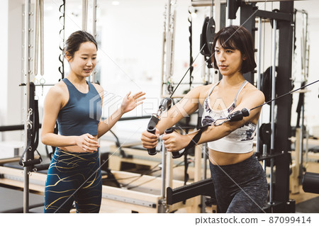 Women doing personal training / machine training / women doing muscle training at the gym Women doing personal training / machine training / women doing muscle training at the gym 87099414
