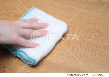 Housewife's hand wiping the table with a towel 87099608