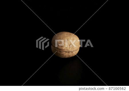 One inshell walnut on a black background 87100562