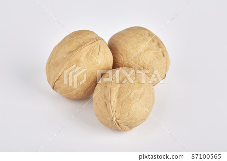 Three walnuts lie side by side on a white background 87100565