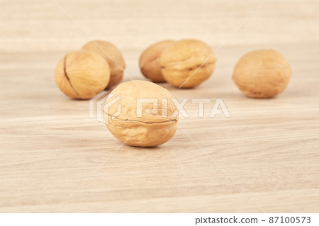 Walnuts lie in the center on a wooden background 87100573