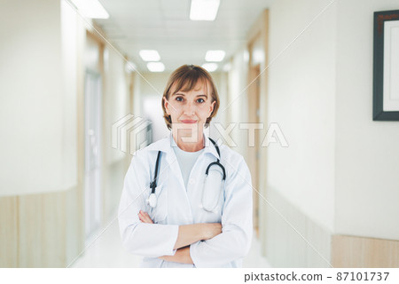 Portrait of caucasian senior woman doctor posing with arms crossed with stethoscope in hospital Portrait of caucasian senior woman doctor posing with arms crossed with stethoscope in hospital 87101737