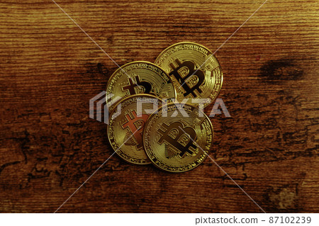 Bitcoins on a wooden background. 87102239