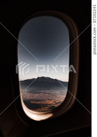 View of the mountain through the window of the plane. View of the mountain through the window of the plane. 87102241
