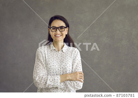 Happy confident smiling caucasian woman looking at camera studio headshot portrait. Casual positive lady showing cheerful emotion sanding on grey background. Feminine and youth, people expression Happy confident smiling caucasian woman looking at camera studio headshot portrait. Casual positive lady showing cheerful emotion sanding on grey background. Feminine and youth, people expression 87103781