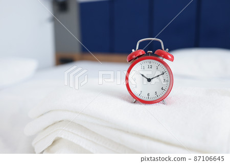 Alarm clock for ten in morning or evening on towels on beds Alarm clock for ten in morning or evening on towels on beds 87106645