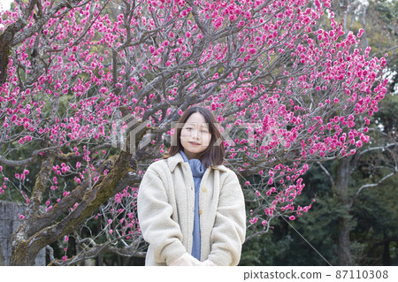 大阪府吹田市 70 年世博會紀念公園內,梅花初開的年輕女子。 大阪府吹田市 70 年世博會紀念公園內,梅花初開的年輕女子。 87110308