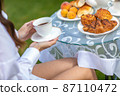 Woman drinking coffee with croissants 87110472