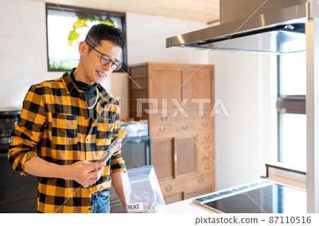 一個男人用鉗子挑選他第一次使用的肉類替代品,一邊看著它們,一邊想知道他是否能吃掉它們。 一個男人用鉗子挑選他第一次使用的肉類替代品,一邊看著它們,一邊想知道他是否能吃掉它們。 87110516