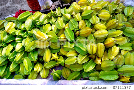 Bunch of star fruit or carambola to sell in local market. Green and yellow color give the unique deliciousness of this rare tropical fruit 87111577
