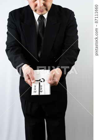 Senior man handing over the incense Senior man handing over the incense 87111660