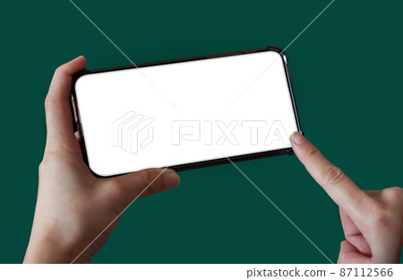 Hand holding white mobile phone with blank white screen Sea green background. 87112566