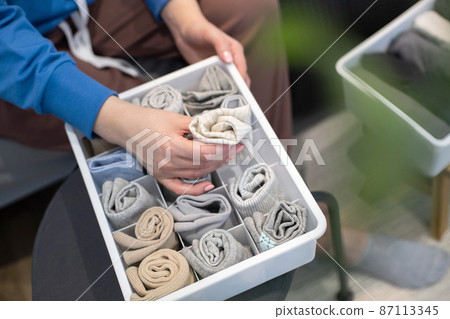 Top view female hands holding organizer drawer divider with socks storage Marie Kondo's method Top view female hands holding organizer drawer divider with socks storage Marie Kondo's method 87113345