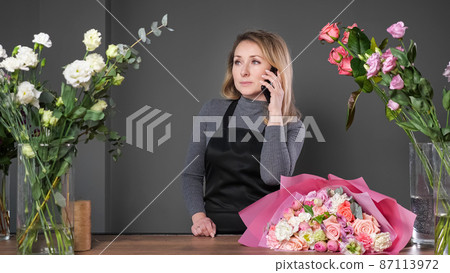 Florist informs customer about composed flowers bouquet 87113972