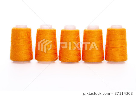 Orange spool of thread isolated on white background. Skein of woolen threads. Yarn for knitting. Materials for sewing machine. Coil. 87114308