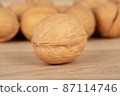 One nut in the foreground the others in the background lie on a wooden table 87114746