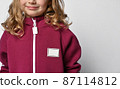 Close-up of a child in a burgundy jumpsuit or 87114812