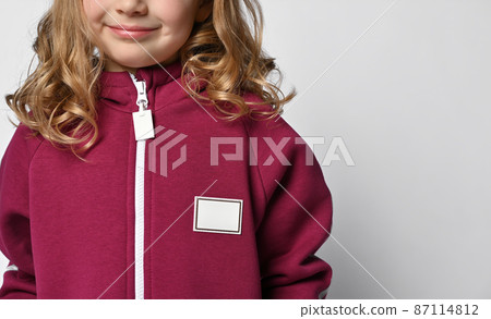 Close-up of a child in a burgundy jumpsuit or Close-up of a child in a burgundy jumpsuit or 87114812