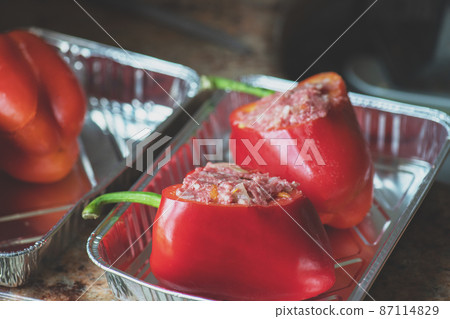 Bell peppers stuffed with minced meat filling in a baking aluminum form. 87114829