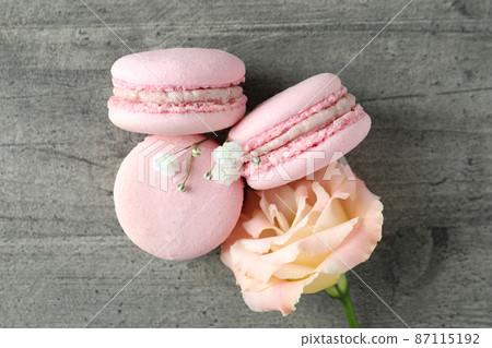 Concept of tasty dessert with macaroons on gray textured table Concept of tasty dessert with macaroons on gray textured table 87115192