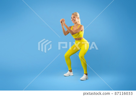 Smiling Young Woman Doing Deep Squat Exercise Smiling Young Woman Doing Deep Squat Exercise 87116033