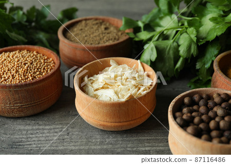 Different spices in wooden bowls on gray textured background Different spices in wooden bowls on gray textured background 87116486