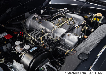 Look under the hood of a retro car in perfect condition, clean engine, lots of levers, hoses and wires, vintage 87116663