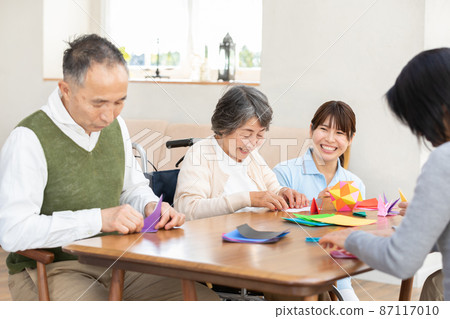 Senior playing with origami Senior playing with origami 87117010