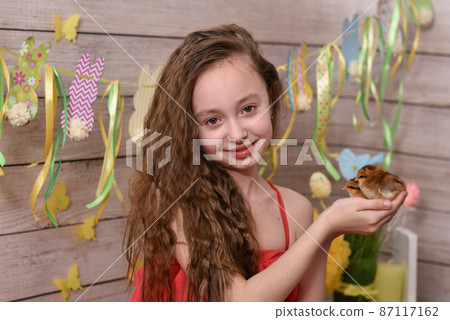 the girl is holding chickens in her hands. happy easter 87117162