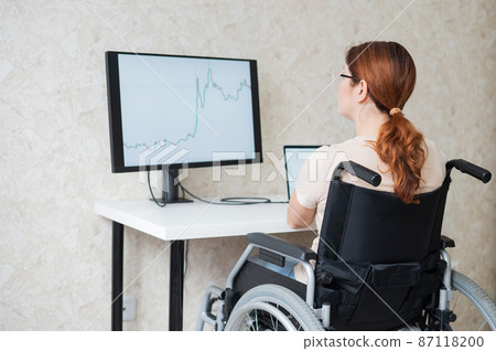 Caucasian woman on wheelchair working on laptop. Caucasian woman on wheelchair working on laptop. 87118200