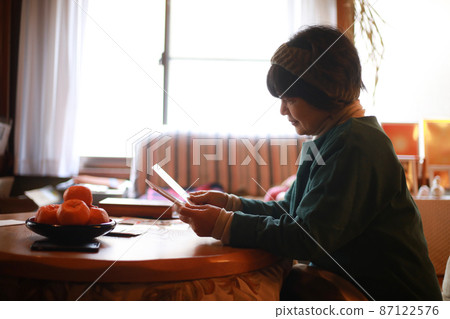 A woman looking at the New Year's card that arrived A woman looking at the New Year's card that arrived 87122576