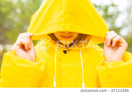 smiling teenage girl wearing raincoat outdoors in rainy day smiling teenage girl wearing raincoat outdoors in rainy day 87122886