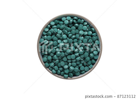 spirulina tablets in a plate on a white background, isolated on a white background. Healthy food supplement. Super food ingredient. top view 87123112