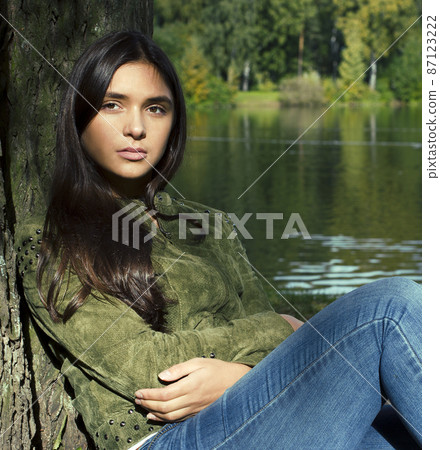Young cute smiling real stylish dressed woman in green palm park smiling, resting, enjoing, lifestyle outside concept Young cute smiling real stylish dressed woman in green palm park smiling, resting, enjoing, lifestyle outside concept 87123222
