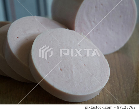 Boiled sausage cut into pieces, a close-up shot. 87123762