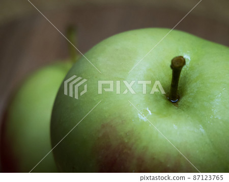 A large green apple, a close-up shot. A wet apple. 87123765