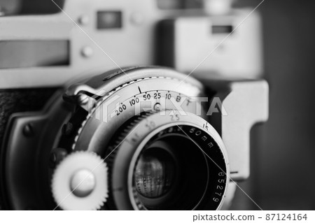 Vintage old photography film camera with lens. Close up macro shot Vintage old photography film camera with lens. Close up macro shot 87124164