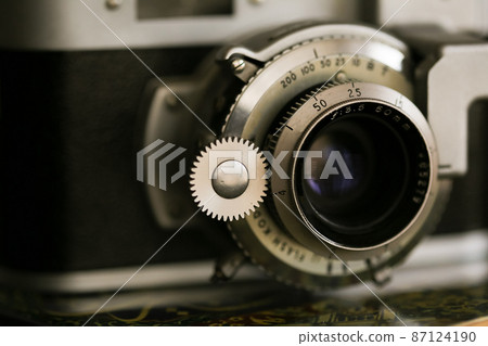 Vintage old photography film camera with lens. Close up macro shot Vintage old photography film camera with lens. Close up macro shot 87124190