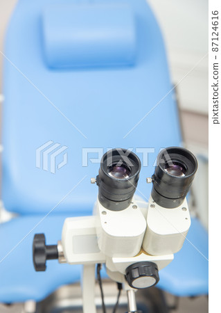 Colposcope closeup on the background of gynecological chair. 87124616