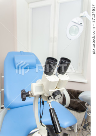 Colposcope closeup on the background of gynecological chair. 87124617