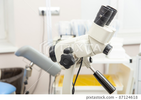 Colposcope closeup on the background of gynecological chair. 87124618