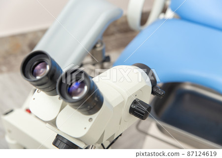 Colposcope closeup on the background of gynecological chair. 87124619