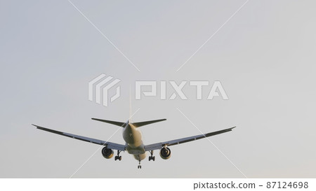 Commercial passenger airplane flying overhead on sunny day Commercial passenger airplane flying overhead on sunny day 87124698