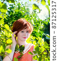 Portrait of a red-haired happy woman in park 87125317